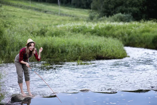 Chica junto al río con una caña de pescar — Foto de Stock