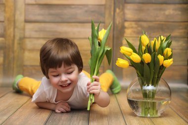 Bir buket Sarı laleler ile küçük bir çocuk. Bir çocuk bir hediye ile