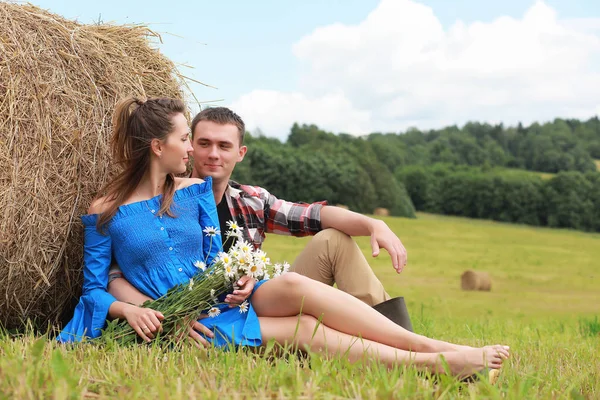 Couple amoureux dans un champ au coucher du soleil — Photo