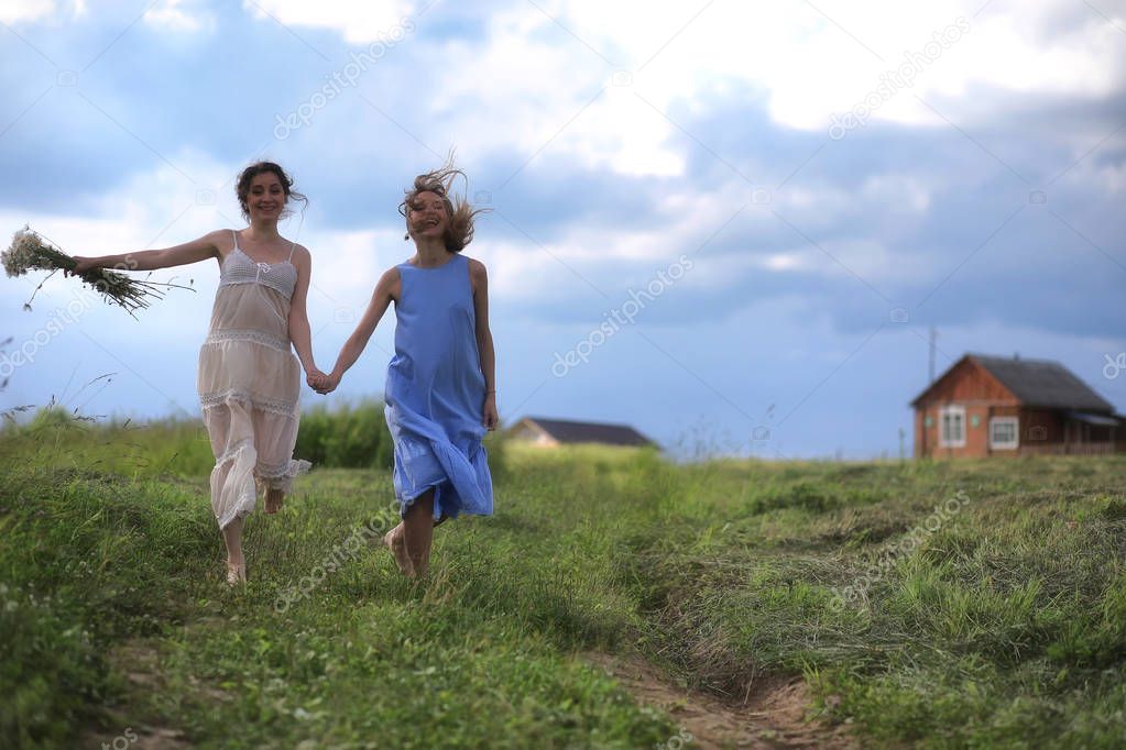 Young girls are walking in the field