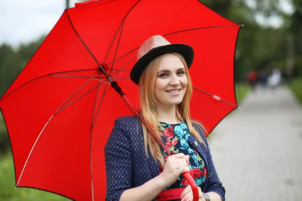 Mädchen auf der Straße mit einem Regenschirm — Stockfoto