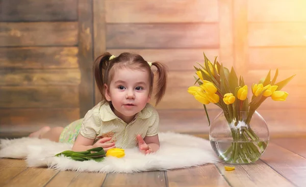 Uma criança pequena com um buquê de tulipas amarelas. Um rapaz com um dom — Fotografia de Stock