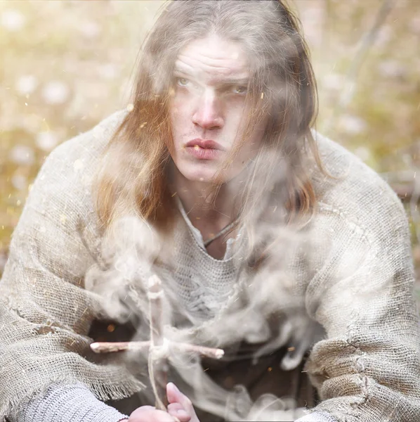Un uomo con una tonaca trascorre un rituale in una foresta oscura — Foto Stock
