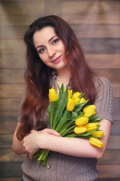 Девушка с букетом желтых тюльпанов. Девушка с цветочным подарком — стоковое фото