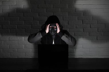 Siyah maske ve hood masada hacker