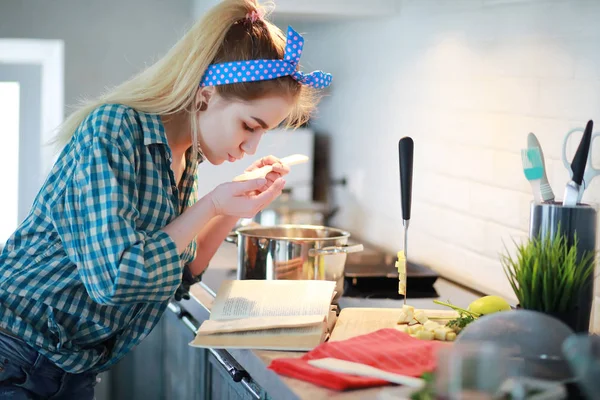 Uma menina bonita na cozinha prepara comida — Fotografia de Stock