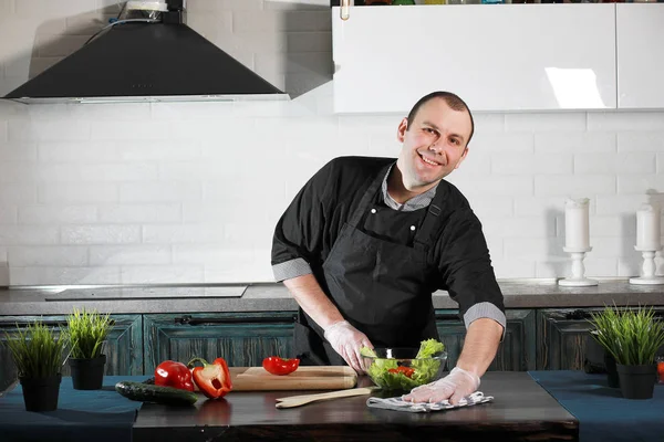 Man cook preparing food at the kitchen of vegetables