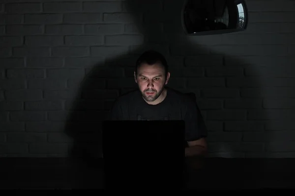 Hacker con máscara negra y capucha en la mesa —  Fotos de Stock
