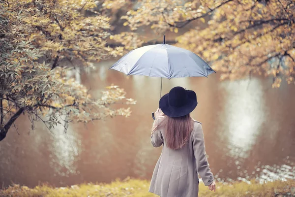 Mladá dívka v kabátě v podzimním parku — Stock fotografie