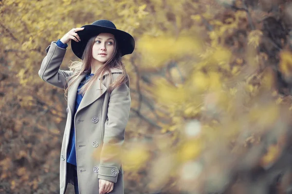 Menina jovem em um casaco no parque de outono — Fotografia de Stock