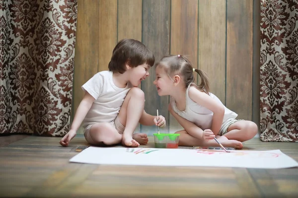 Petits enfants peignent sur une grande feuille de papier — Photo