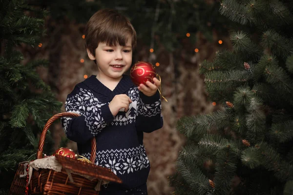 A little child by the New Year tree. Children decorate the Chris — Stock Photo, Image