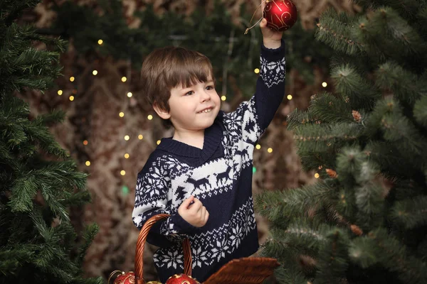 Un copil mic lângă copacul de Anul Nou. Copiii îl decorează pe Chris — Fotografie, imagine de stoc