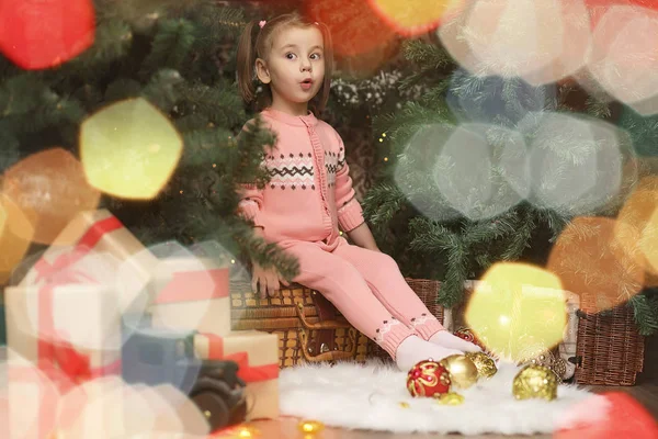 Kleines Mädchen in weihnachtlicher Atmosphäre. Das Mädchen ist happ — Stockfoto