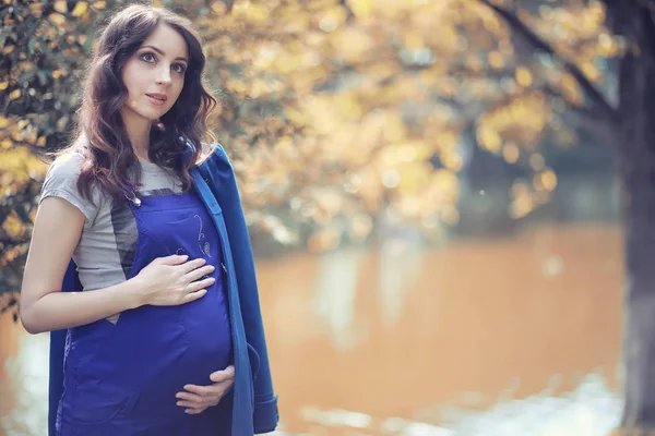 Femme enceinte en promenade dans le parc — Photo