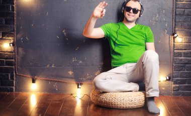 Genç adam kulaklıkla müzik dinliyor.