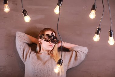 Siyah bir maske içinde sarı saçlı bir kızla