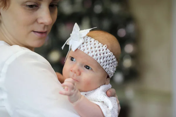 Csinos fiatal anya kezében egy újszülött lánya karjaiban — Stock Fotó