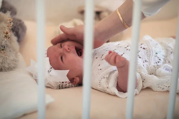 Carino neonato si trova nella culla e guardando la madre — Foto Stock