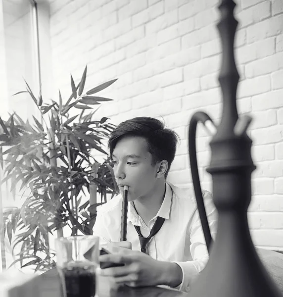 Um jovem empresário asiático está esperando por um parceiro em um café. Bu... — Fotografia de Stock