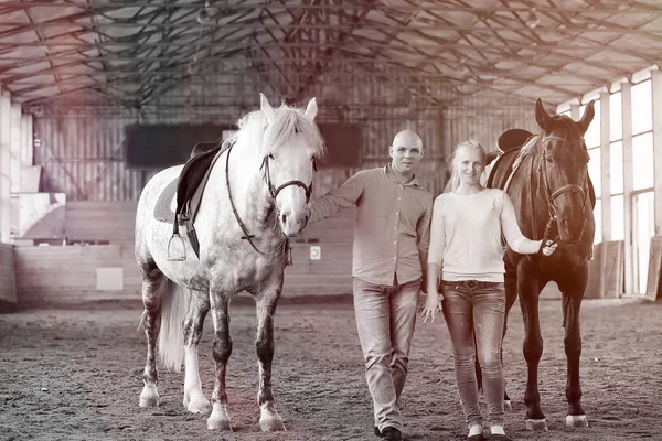 Jongeren op een paardentraining in houten arena — Stockfoto