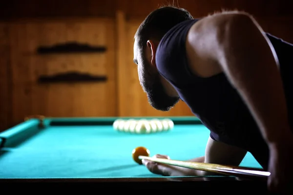 A man with a beard plays a big billiard. Party in a 12-foot pool — Stock Photo, Image