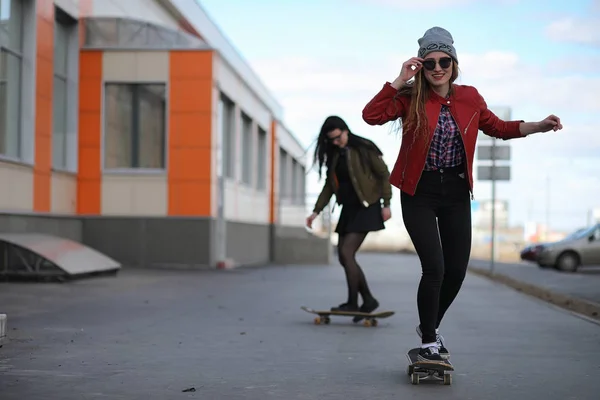 Een meisje van jonge hipster is een skateboard rijden. Meisjes vriendinnen f — Stockfoto