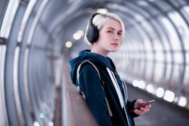 Genç öğrenci metro büyük kulaklıklar müzik dinlemek