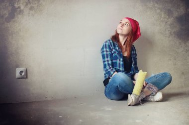 Kız dairede tamirat yapıyor. Eve yeni bir daireye taşınıyor. İşçi onarım, sıvalı yapar ve duvar matkaplar.