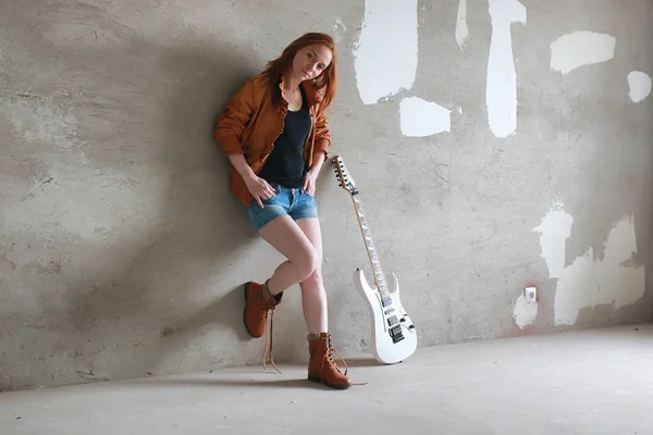 Menina ruiva jovem com uma guitarra elétrica. Músico de rock gir — Fotografia de Stock