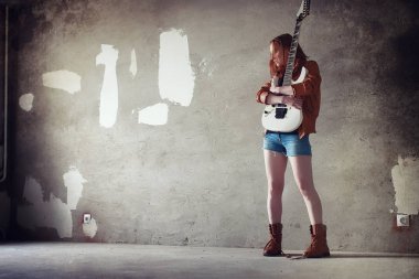 Kızıl saçlı kız bir elektro gitar ile. Rock müzisyen GIR