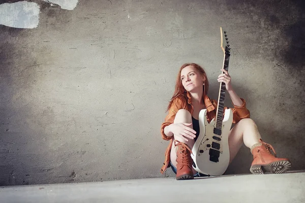 Menina ruiva jovem com uma guitarra elétrica. Músico de rock gir — Fotografia de Stock
