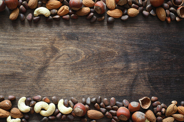 Разные орехи на деревянном столе. Кедр, кешью, фундук, вальну
