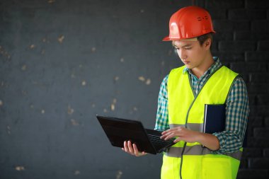 Kask ve inşaat koruyucu yelek Asyalı adam