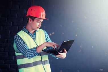 Kask ve inşaat koruyucu yelek Asyalı adam