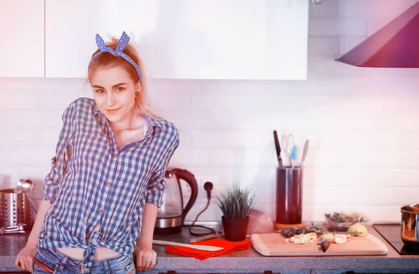 Ένα χαριτωμένο νεαρή κοπέλα στην κουζίνα προετοιμάζει τροφίμων — Φωτογραφία Αρχείου
