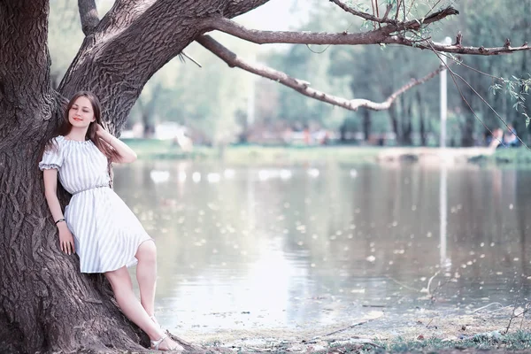 Uma menina em um parque verde primavera — Fotografia de Stock