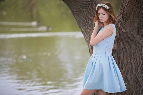 Κορίτσι με μπλε φόρεμα σε καταπράσινο πάρκο — Φωτογραφία Αρχείου