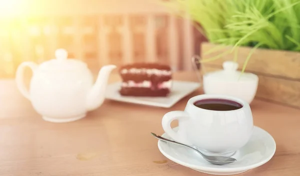 Kettle with a drink and dessert in a street cafe. Tea in the ket — Stock Photo, Image