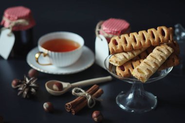 Kahvaltı için ayarlayın. Tatlılar ve fındıklı çay siyah arka plan üzerine hamur işleri. Bir fincan kahve ve köftesi.