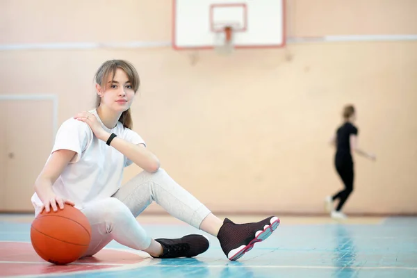 Dziewczyna w siłowni gry w koszykówkę — Zdjęcie stockowe