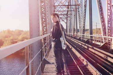 Bir elektro gitar demiryolu üzerinde olan bir adam. Bir Le bir müzisyen