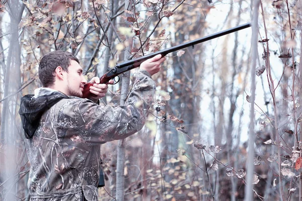 Kamuflaj ve bir sp üzerinde bir ormanda bir av tüfeği ile bir adam — Stok fotoğraf
