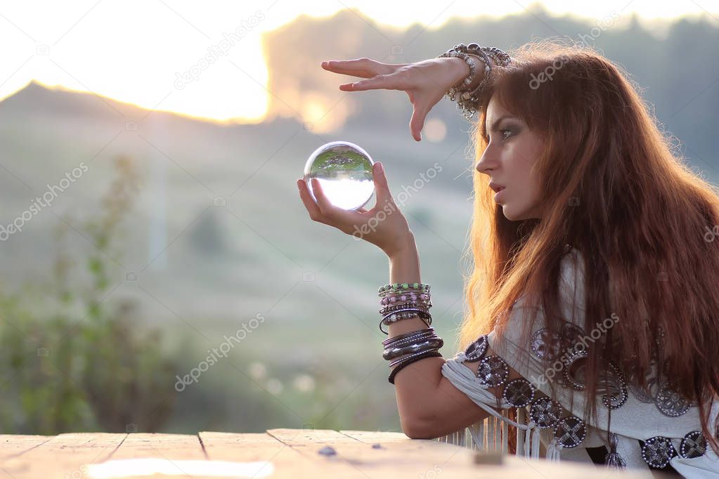 witch with crystal ball at sunset