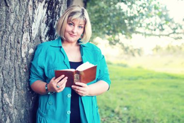 kadın yatıyordu ve kitap Güneş okuyun