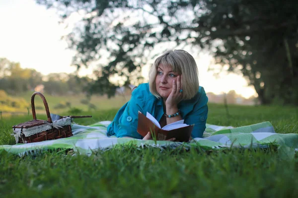 Mujer en el parque con libro sobre la hierba —  Fotos de Stock
