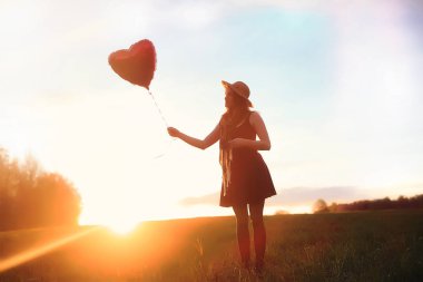 Parkta bir yürüyüş üzerinde şapkalı bir kız. Bir kızla bir sepet yürüyüş