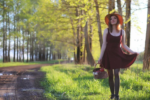 A girl in a hat on a walk in the park. A girl with a basket walk — Stock Photo, Image