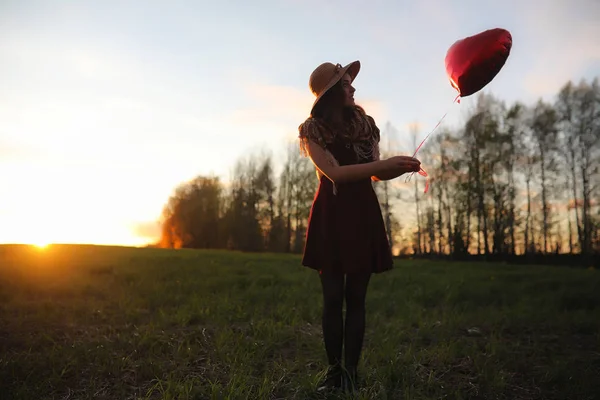 En flicka i en hatt på en promenad i parken. En flicka med en korg promenad — Stockfoto