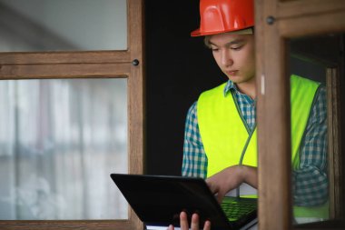 Kask ve inşaat koruyucu yelek Asyalı adam